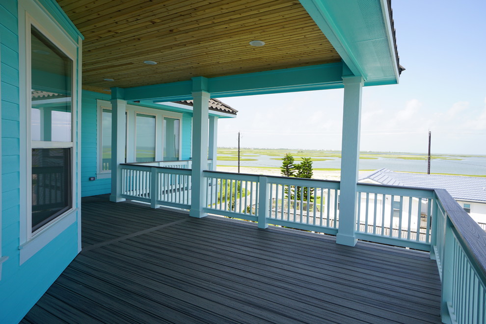 Inspiration for a large beach style backyard deck in Houston with a roof extension.