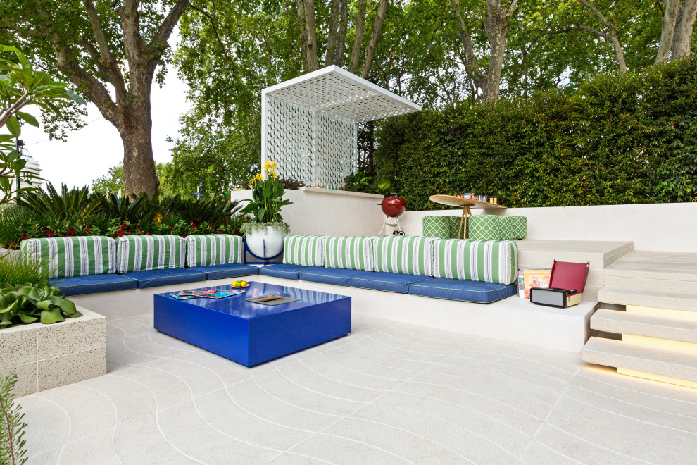 Inspiration for a large tropical backyard patio in Melbourne with a fire feature, concrete pavers and a pergola.