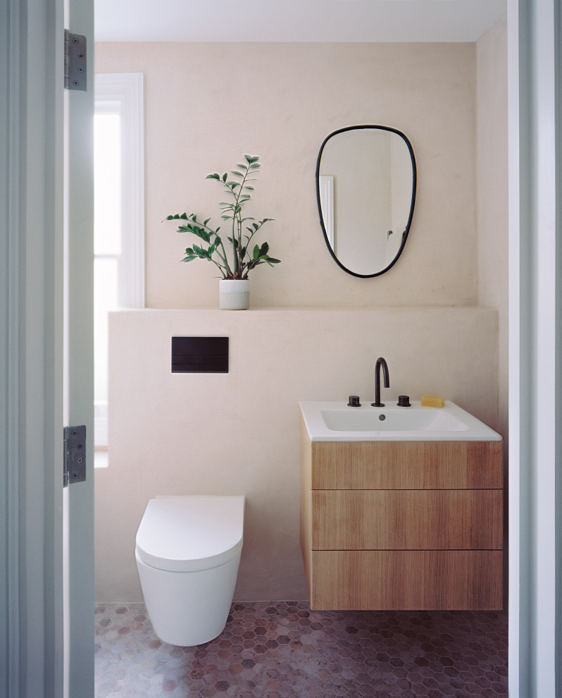 Пример оригинального дизайна: детская ванная комната среднего размера: освещение в скандинавском стиле с плоскими фасадами, фасадами цвета дерева среднего тона, накладной ванной, душем над ванной, инсталляцией, розовой плиткой, розовыми стенами, мраморным полом, монолитной раковиной, столешницей из искусственного камня, розовым полом, открытым душем, белой столешницей, тумбой под одну раковину и подвесной тумбой