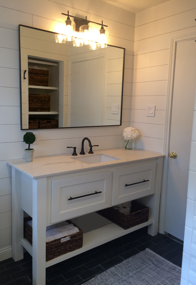 Photo of a mid-sized scandinavian 3/4 bathroom in Houston with furniture-like cabinets, white cabinets, an alcove tub, a shower/bathtub combo, a two-piece toilet, white tile, white walls, slate floors, an undermount sink, marble benchtops, black floor, a shower curtain and subway tile.