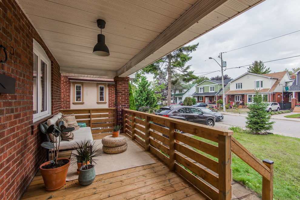 This is an example of a mid-sized scandinavian front yard patio in Toronto with a roof extension.
