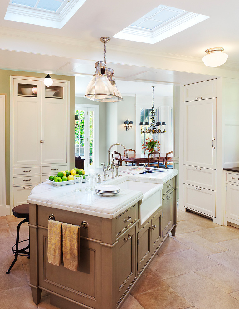 This is an example of a traditional separate kitchen in DC Metro with marble benchtops, a farmhouse sink, recessed-panel cabinets, panelled appliances, grey cabinets, limestone floors and with island.