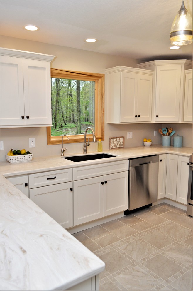 This is an example of a mid-sized transitional u-shaped eat-in kitchen in Other with an undermount sink, shaker cabinets, white cabinets, solid surface benchtops, stainless steel appliances, ceramic floors, a peninsula, beige floor and white benchtop.