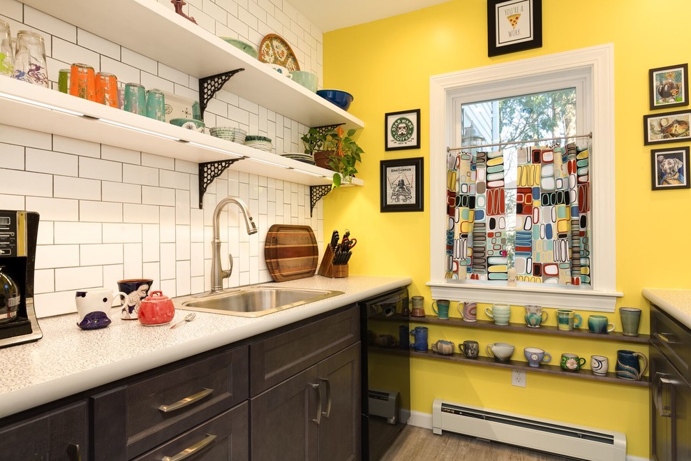 Photo of a small midcentury galley eat-in kitchen in Providence with a drop-in sink, flat-panel cabinets, white cabinets, laminate benchtops, white splashback, subway tile splashback, black appliances, vinyl floors, no island and grey floor.