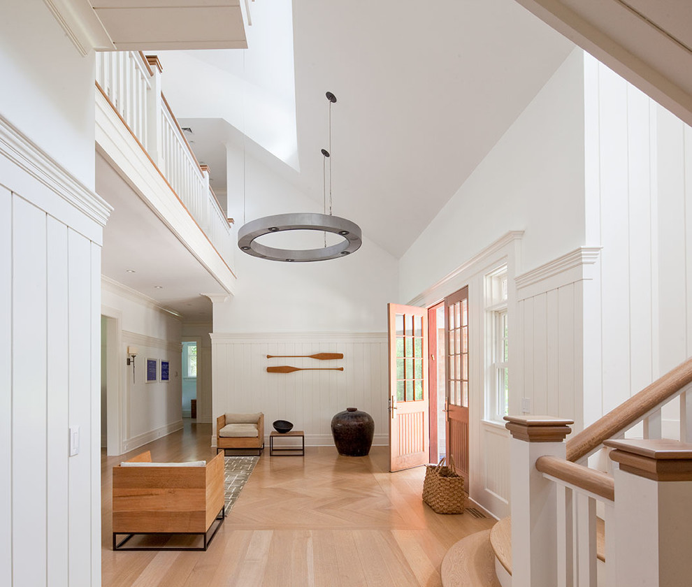 Photo of an expansive beach style foyer in Los Angeles with white walls, light hardwood floors, a double front door and a light wood front door.