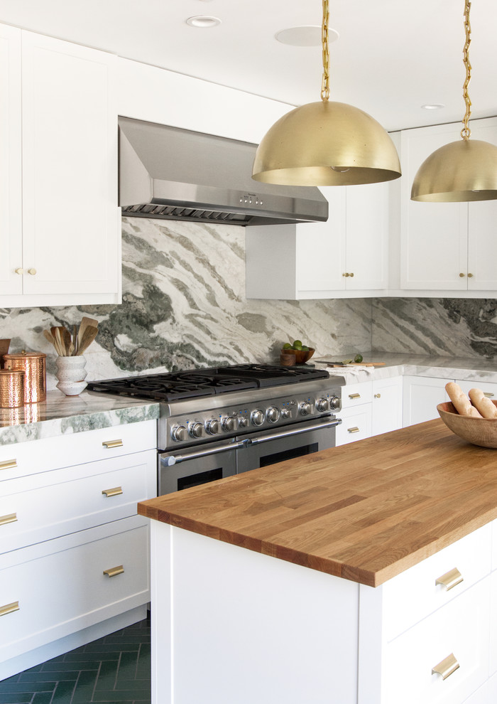 Large contemporary l-shaped separate kitchen in Los Angeles with recessed-panel cabinets, white cabinets, marble benchtops, multi-coloured splashback, marble splashback, stainless steel appliances, brick floors, with island, green floor and green benchtop.