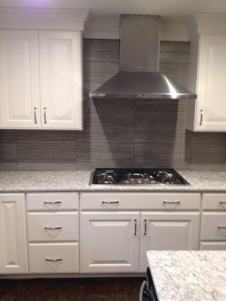 Eat-in kitchen - mid-sized transitional single-wall dark wood floor eat-in kitchen idea in Chicago with raised-panel cabinets, white cabinets, granite countertops, gray backsplash, ceramic backsplash, stainless steel appliances and an island
