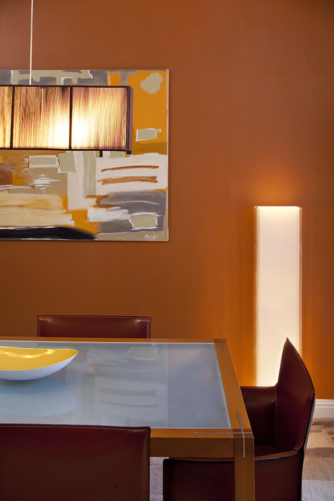 Contemporary dining room in Dallas with orange walls.