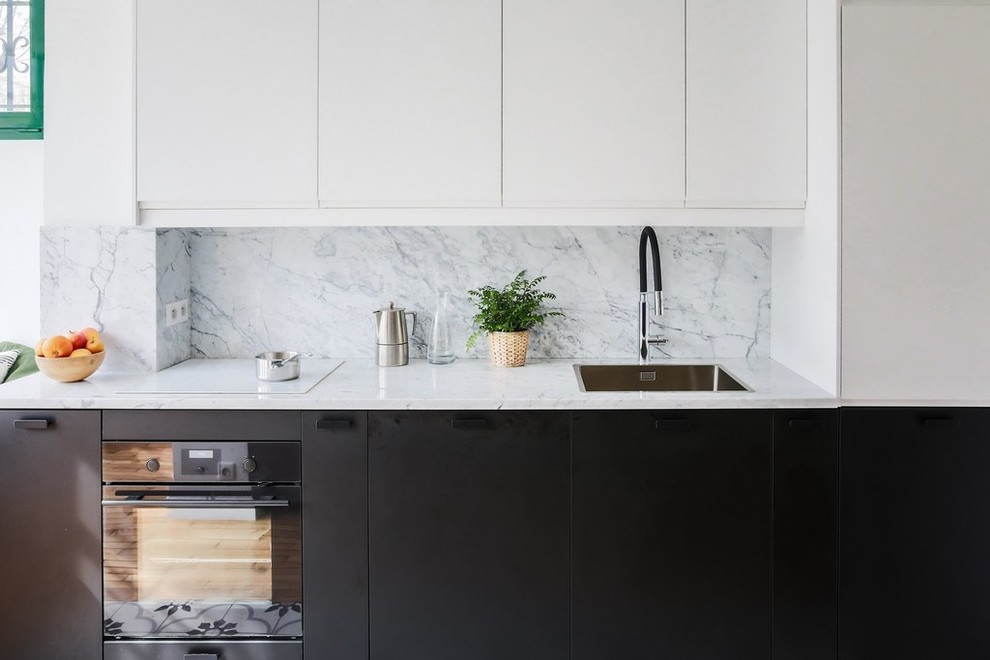 Photo of a mid-sized contemporary galley eat-in kitchen in Paris with an undermount sink, flat-panel cabinets, black cabinets, marble benchtops, grey splashback, marble splashback, black appliances, cement tiles, with island, multi-coloured floor and grey benchtop.