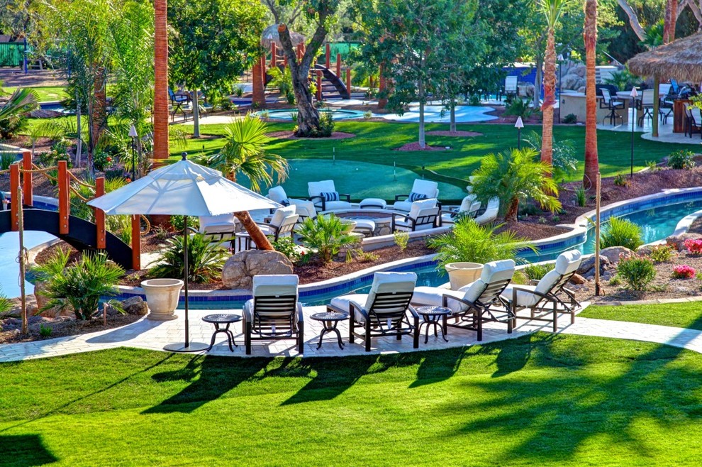 Photo of an expansive tropical backyard partial sun garden in Phoenix with a garden path and concrete pavers.