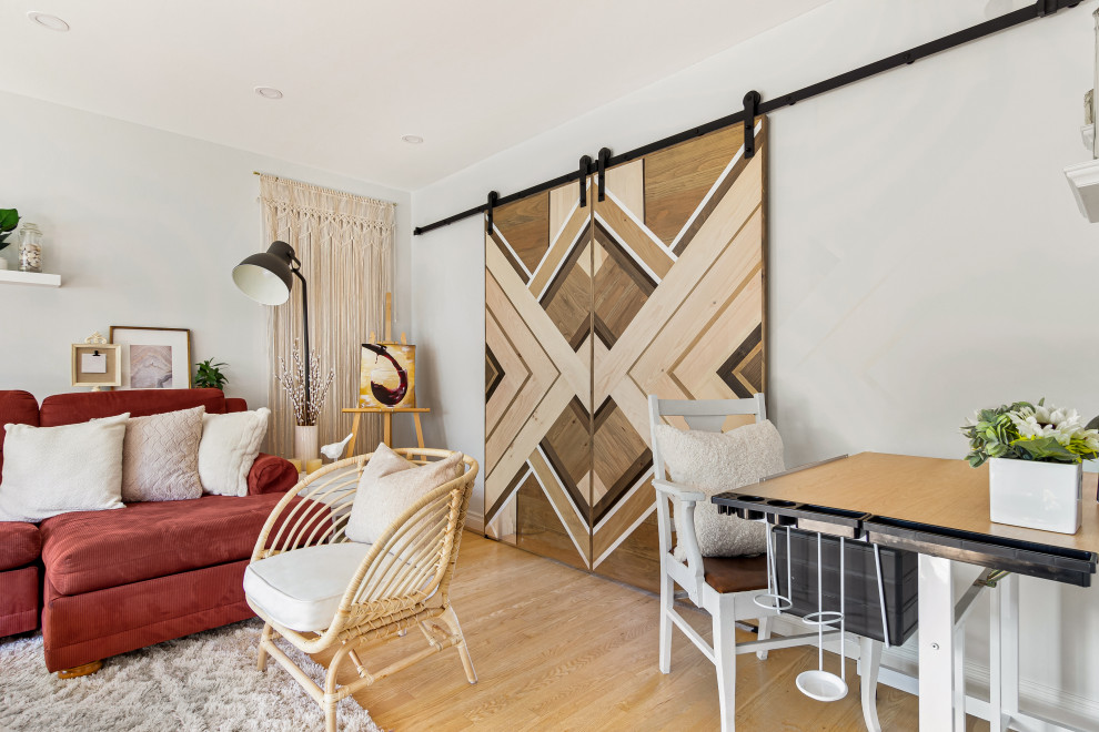 Skandinavisk inredning av ett mellanstort vardagsrum, med vita väggar, ljust trägolv, en öppen vedspis, en spiselkrans i sten, en väggmonterad TV och brunt golv