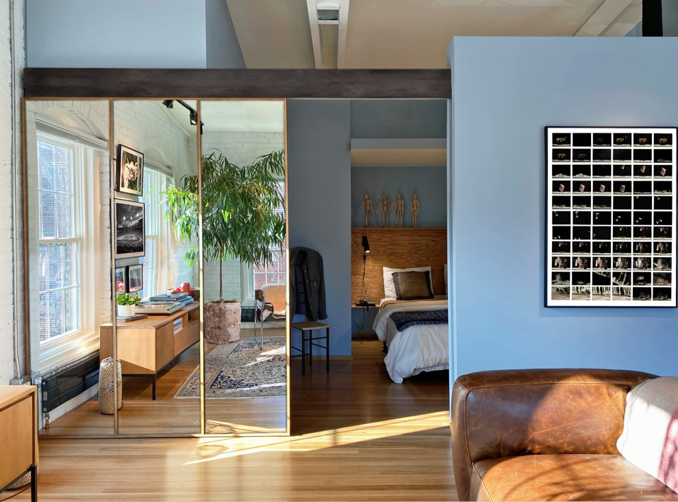 Esempio di un piccolo soggiorno contemporaneo stile loft con pareti blu, pavimento in legno massello medio, nessun camino, TV a parete, travi a vista e pareti in mattoni