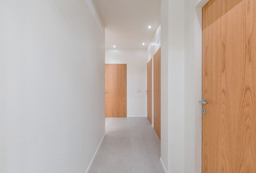 Стильный дизайн: коридор среднего размера в современном стиле с белыми стенами, полом из керамогранита, серым полом и многоуровневым потолком - последний тренд