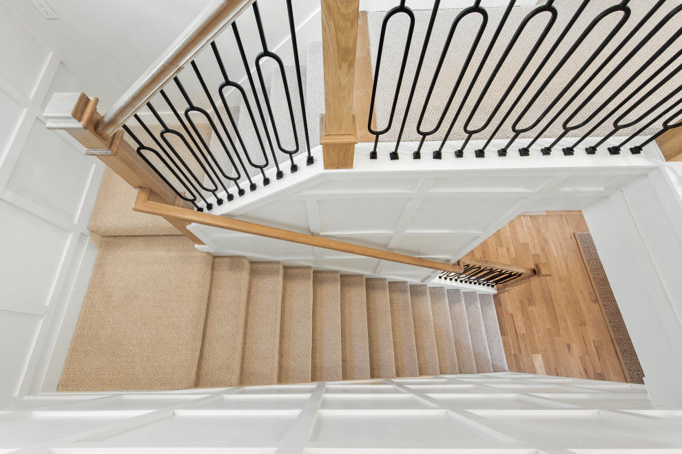 Ejemplo de escalera en U clásica renovada grande con escalones enmoquetados, contrahuellas enmoquetadas, barandilla de metal y panelado