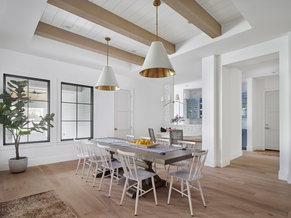 Large country open plan dining in Phoenix with light hardwood floors, beige floor and white walls.