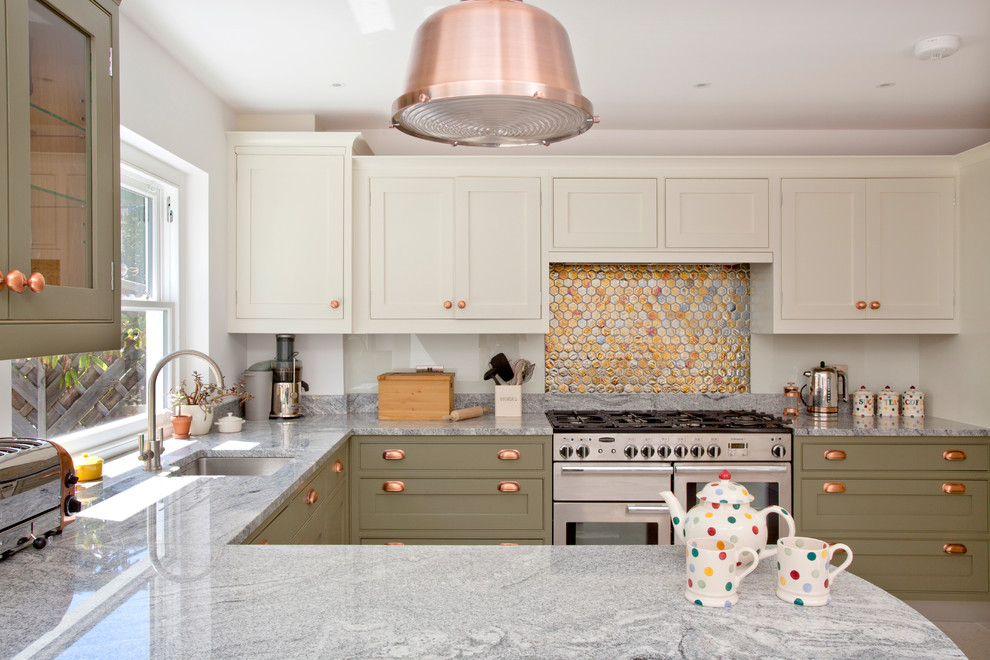 Inspiration for a transitional u-shaped kitchen in London with an undermount sink, shaker cabinets, green cabinets, metallic splashback, mosaic tile splashback, stainless steel appliances and a peninsula.