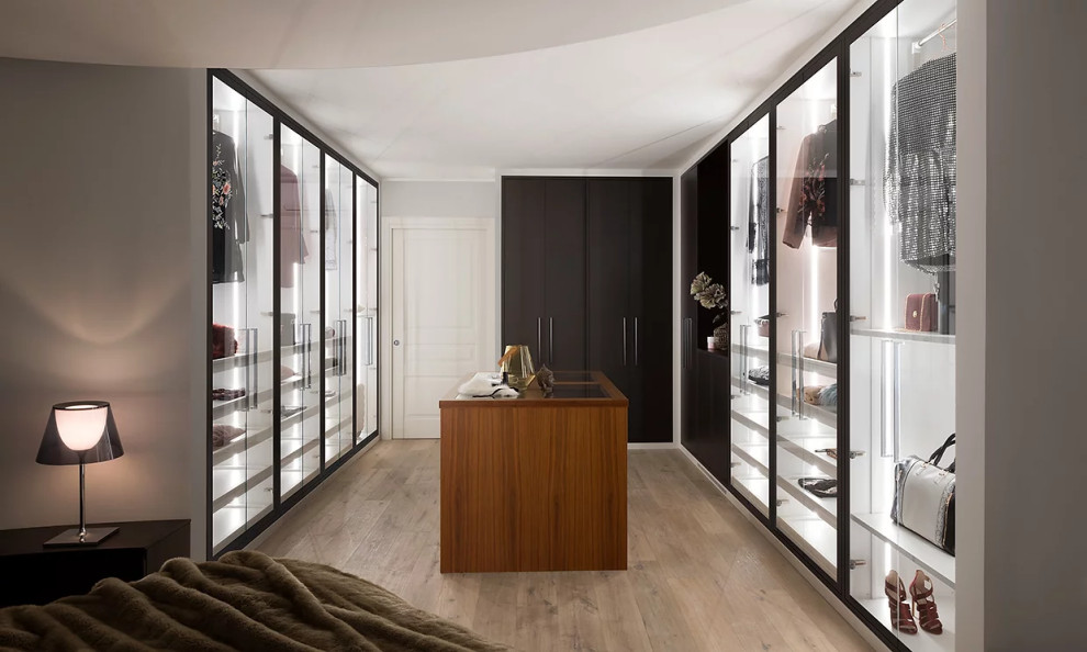 Design ideas for a mid-sized modern gender-neutral walk-in wardrobe in New York with beaded inset cabinets, white cabinets, light hardwood floors, white floor and wood.