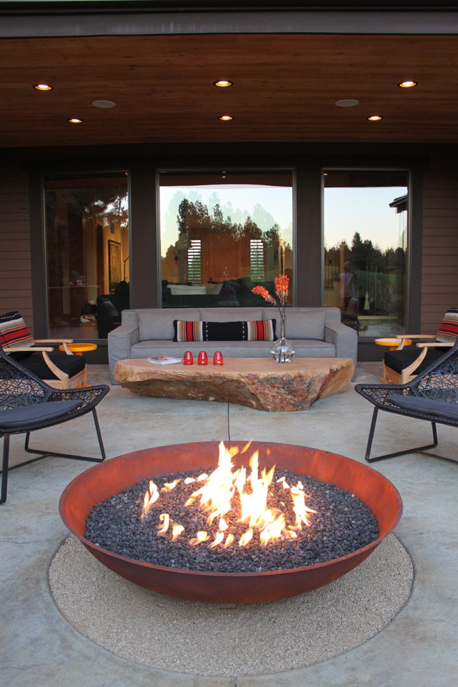 Large contemporary backyard patio in Other with a fire feature, concrete slab and a roof extension.