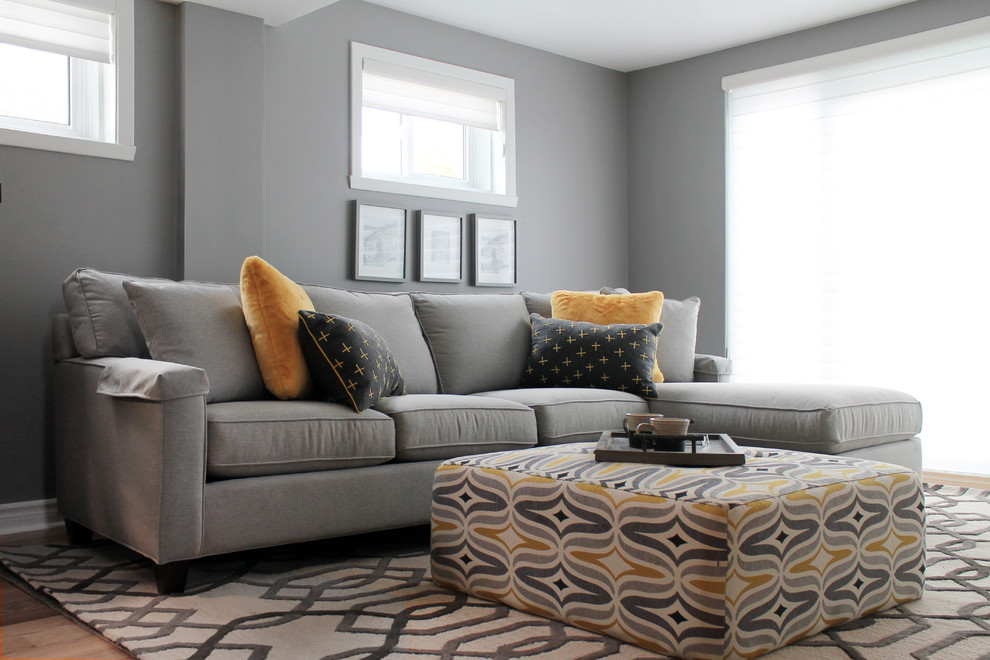 Inspiration for a mid-sized timeless enclosed light wood floor family room remodel in Other with gray walls and a media wall