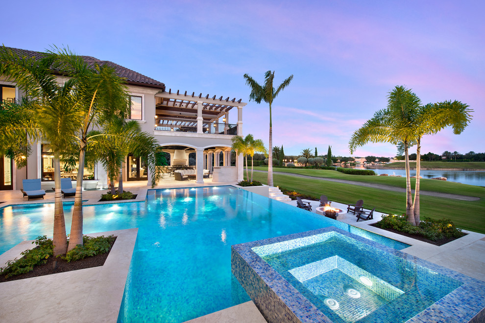 This is an example of an expansive transitional backyard custom-shaped infinity pool in Miami.
