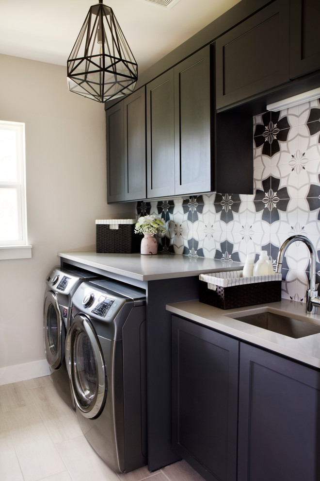 Inspiration for a mid-sized transitional utility room in Austin with an undermount sink, shaker cabinets, dark wood cabinets, quartz benchtops, grey walls, porcelain floors and a side-by-side washer and dryer.