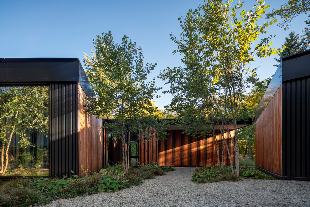 This is an example of a modern one-storey black house exterior in Chicago with wood siding and a flat roof.