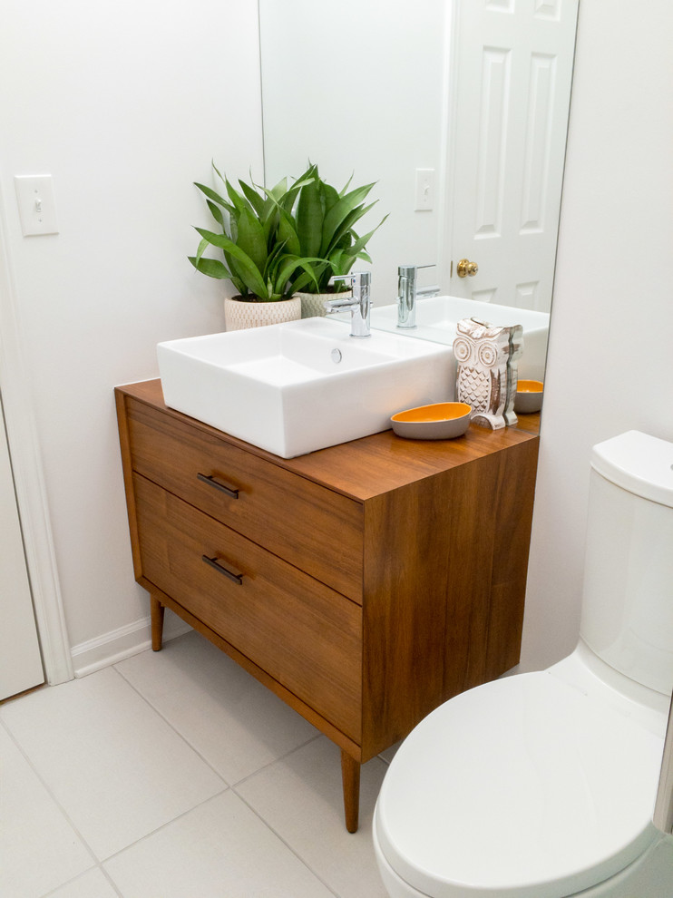 Inspiration for a small midcentury 3/4 bathroom in Raleigh with furniture-like cabinets, medium wood cabinets, an alcove shower, a one-piece toilet, multi-coloured tile, porcelain tile, white walls, porcelain floors, a vessel sink, wood benchtops, grey floor and a sliding shower screen.