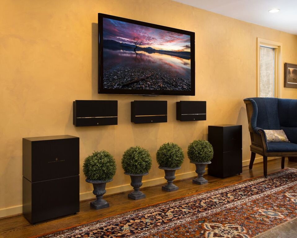 Inspiration for a mid-sized traditional enclosed home theatre in Other with yellow walls, dark hardwood floors, a wall-mounted tv and brown floor.
