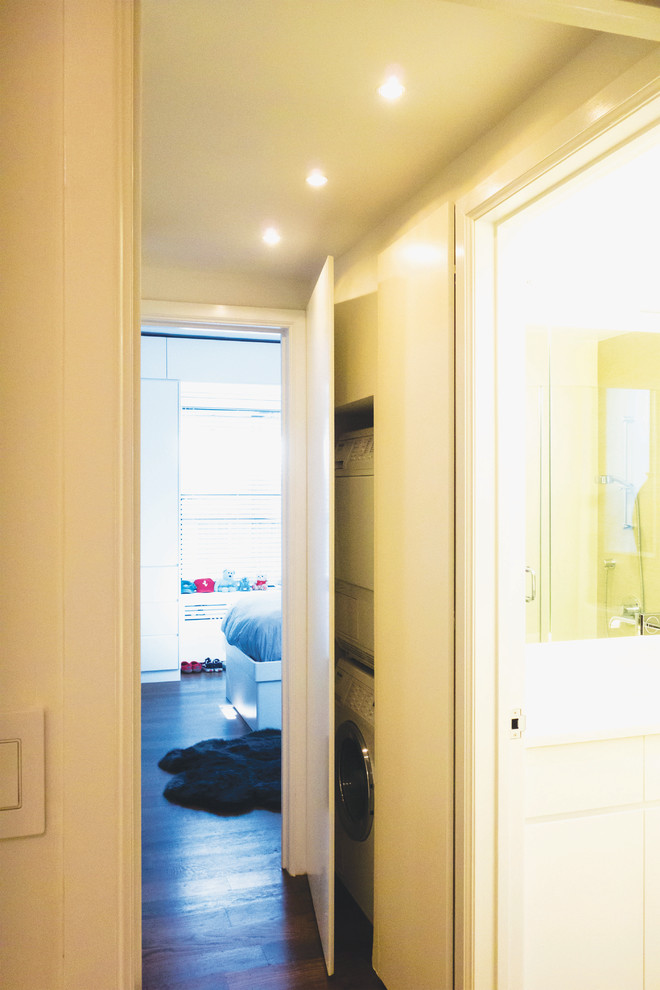 This is an example of a mid-sized modern hallway in New York with white walls and medium hardwood floors.