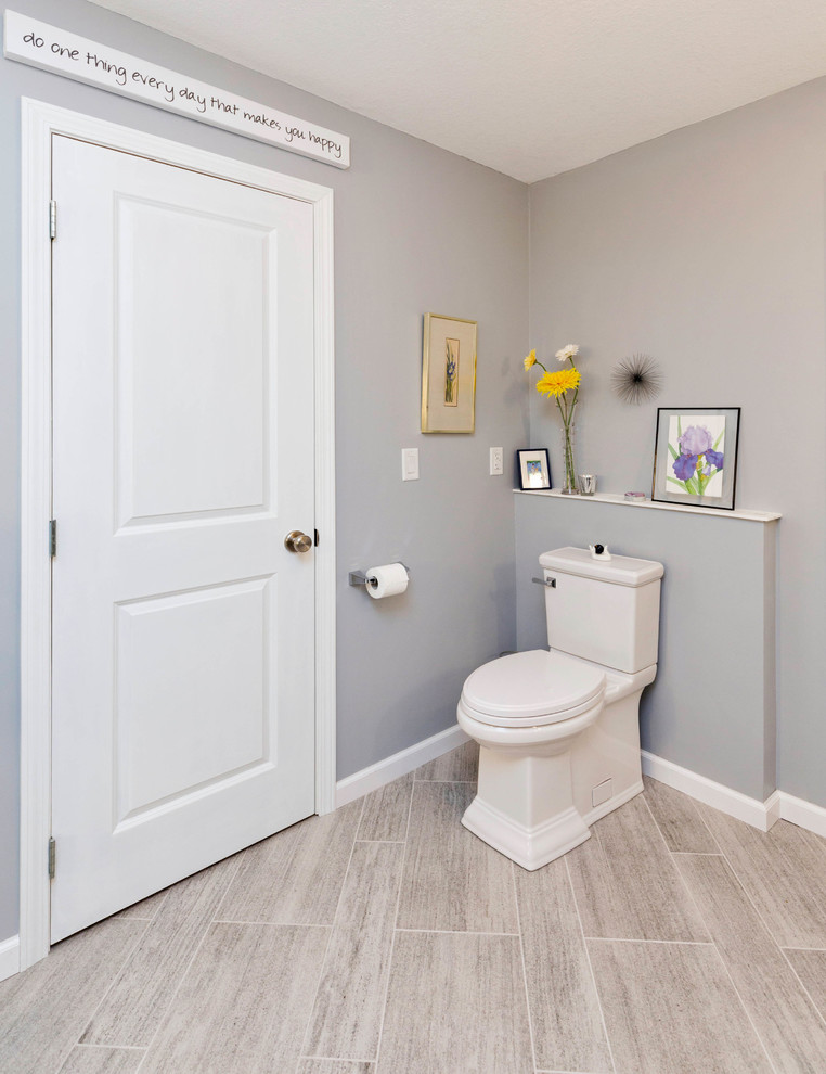 Inspiration for a large modern powder room in Other with recessed-panel cabinets, grey cabinets, a one-piece toilet, white tile, marble, grey walls, slate floors, a drop-in sink, quartzite benchtops and beige floor.