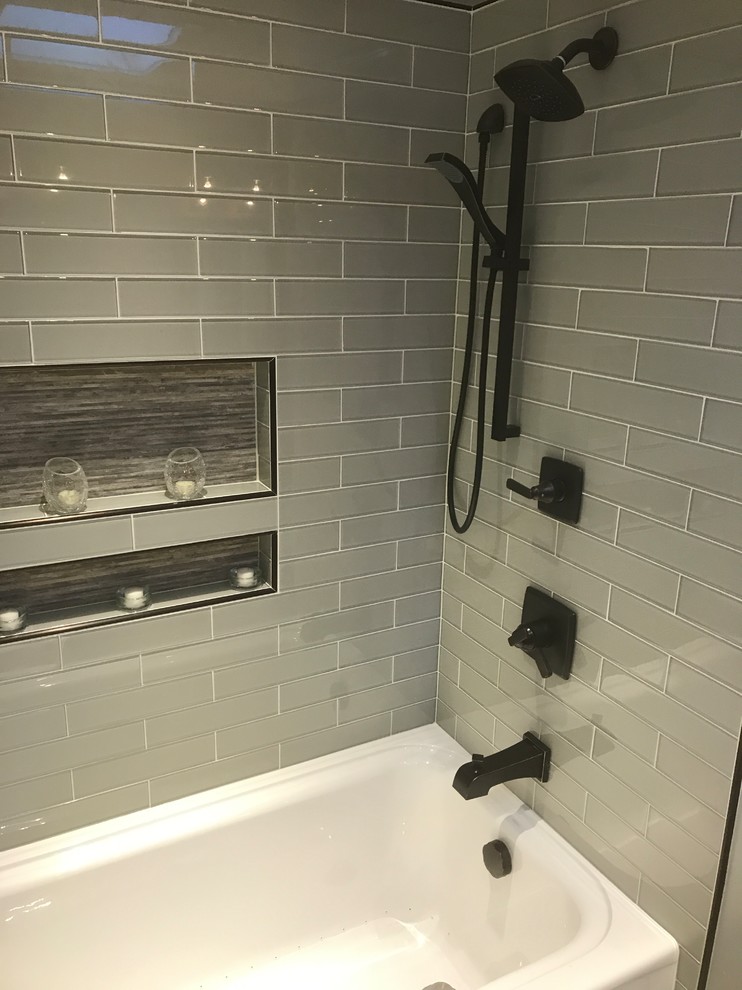 Inspiration for a mid-sized transitional master bathroom in Denver with recessed-panel cabinets, beige cabinets, a drop-in tub, a shower/bathtub combo, gray tile, glass tile, grey walls, porcelain floors, an undermount sink, engineered quartz benchtops, multi-coloured floor and a shower curtain.
