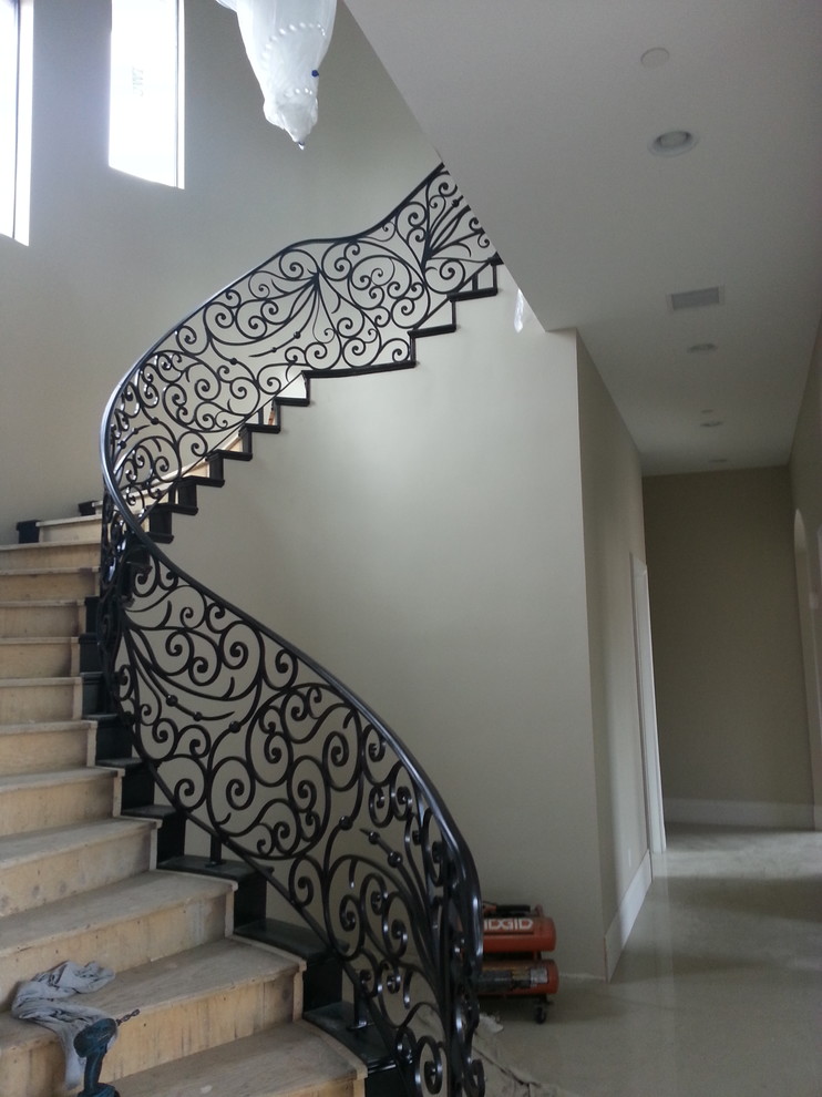 This is an example of a large eclectic wood curved staircase in Las Vegas with wood risers.