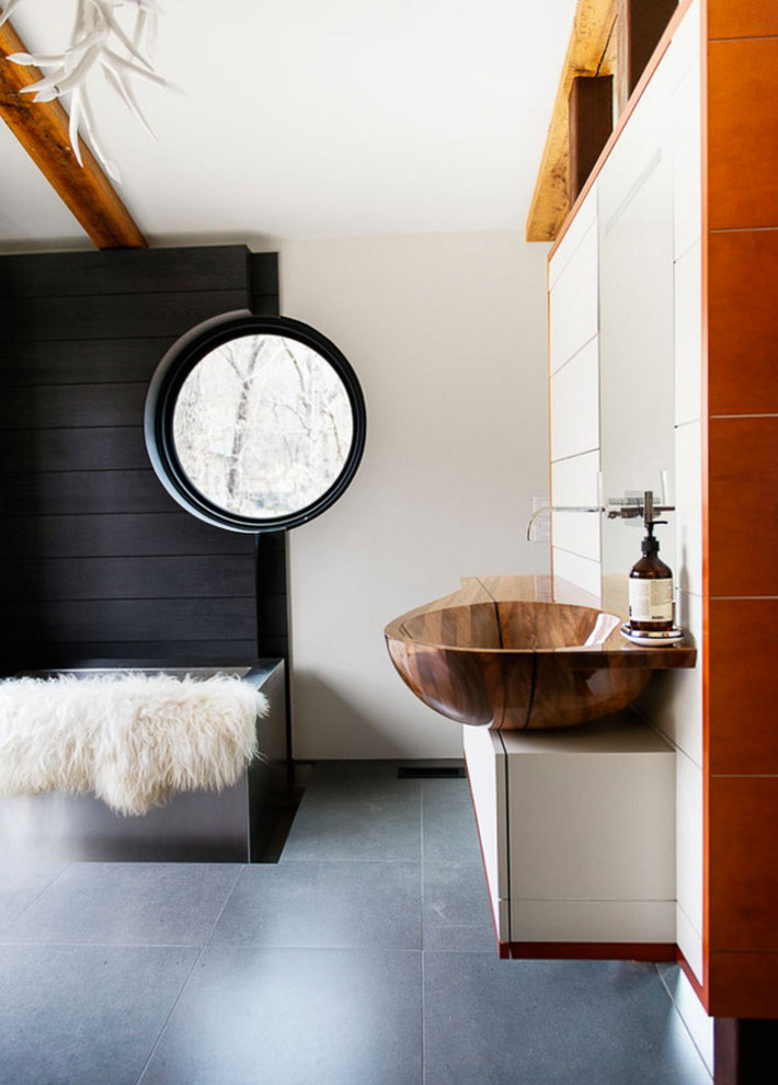 Photo of a contemporary bathroom in Other with flat-panel cabinets, white cabinets, white walls and a vessel sink.