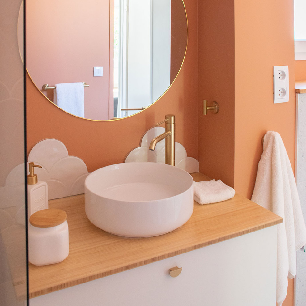 Idée de décoration pour une petite salle de bain minimaliste pour enfant avec une baignoire encastrée, WC suspendus, un carrelage blanc, des carreaux de céramique, un mur orange, un sol en terrazzo, un plan de toilette en bois, un sol gris, une fenêtre et meuble simple vasque.