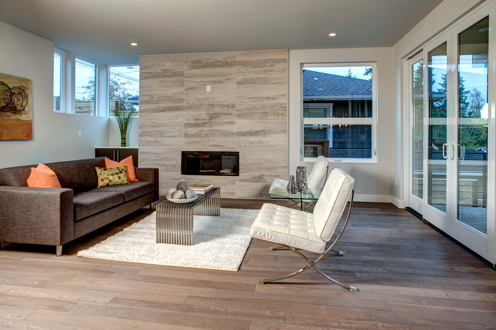 This is an example of a mid-sized contemporary open concept living room in Seattle with white walls, a standard fireplace and a wall-mounted tv.