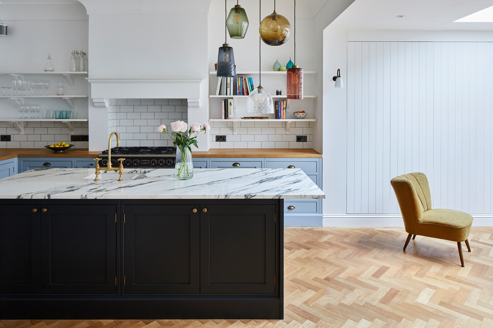 A kitchen with a marble island and a wood floor