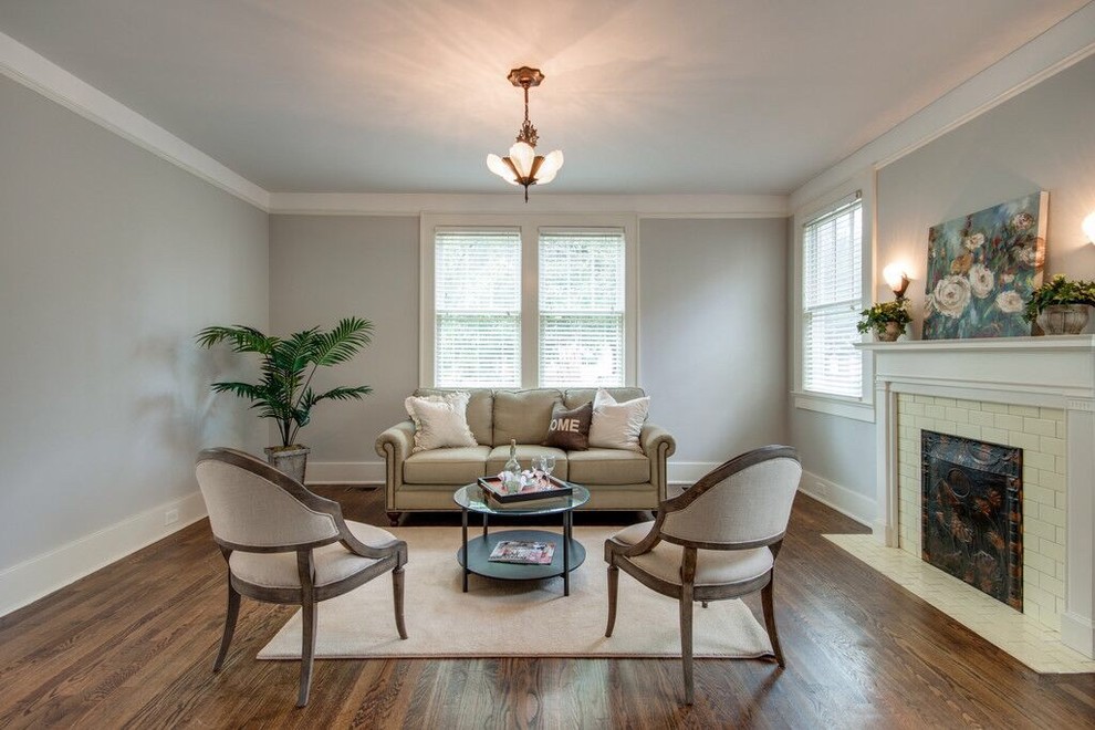 Elegant formal medium tone wood floor living room photo in Charleston with gray walls, a standard fireplace, no tv and a tile fireplace