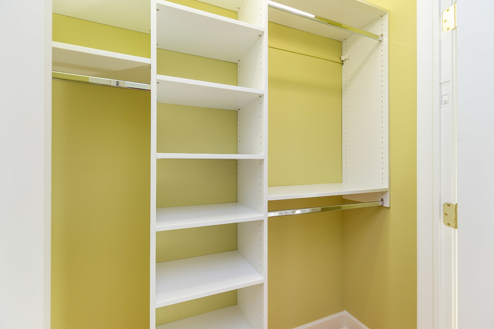 This is an example of a mid-sized transitional gender-neutral built-in wardrobe in Baltimore with open cabinets, white cabinets and medium hardwood floors.