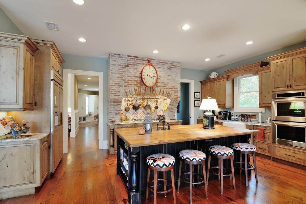 Inspiration for a traditional kitchen in Atlanta with raised-panel cabinets, medium wood cabinets, stainless steel appliances and medium hardwood floors.