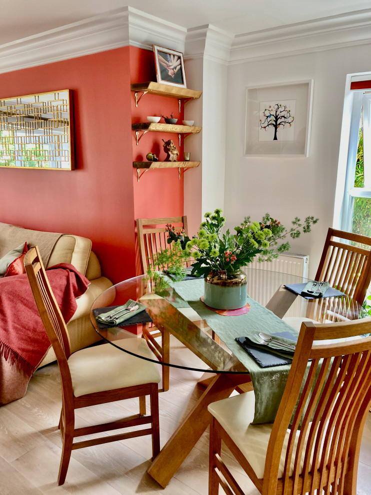 Свежая идея для дизайна: кухня-столовая в стиле модернизм с оранжевыми стенами и полом из ламината - отличное фото интерьера