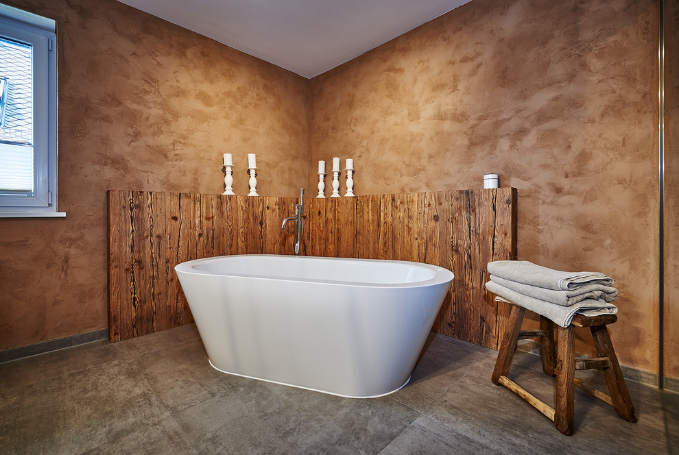 Mid-sized contemporary bathroom in Munich with a freestanding tub and brown walls.