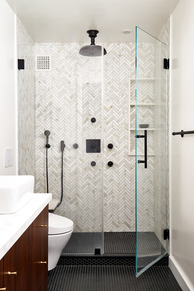 Small trendy 3/4 marble tile mosaic tile floor and black floor alcove shower photo in New York with flat-panel cabinets, medium tone wood cabinets, white walls, a vessel sink, a hinged shower door and white countertops