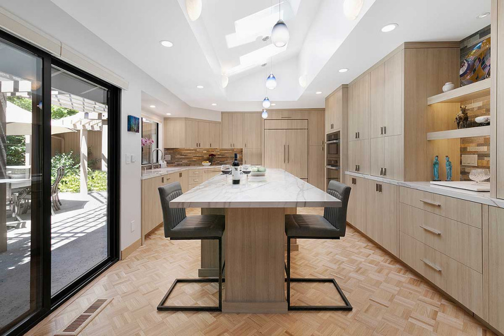 This is an example of a large contemporary l-shaped eat-in kitchen in San Francisco with an undermount sink, flat-panel cabinets, light wood cabinets, multi-coloured splashback, stone tile splashback, panelled appliances, plywood floors, with island, beige floor, white benchtop and vaulted.