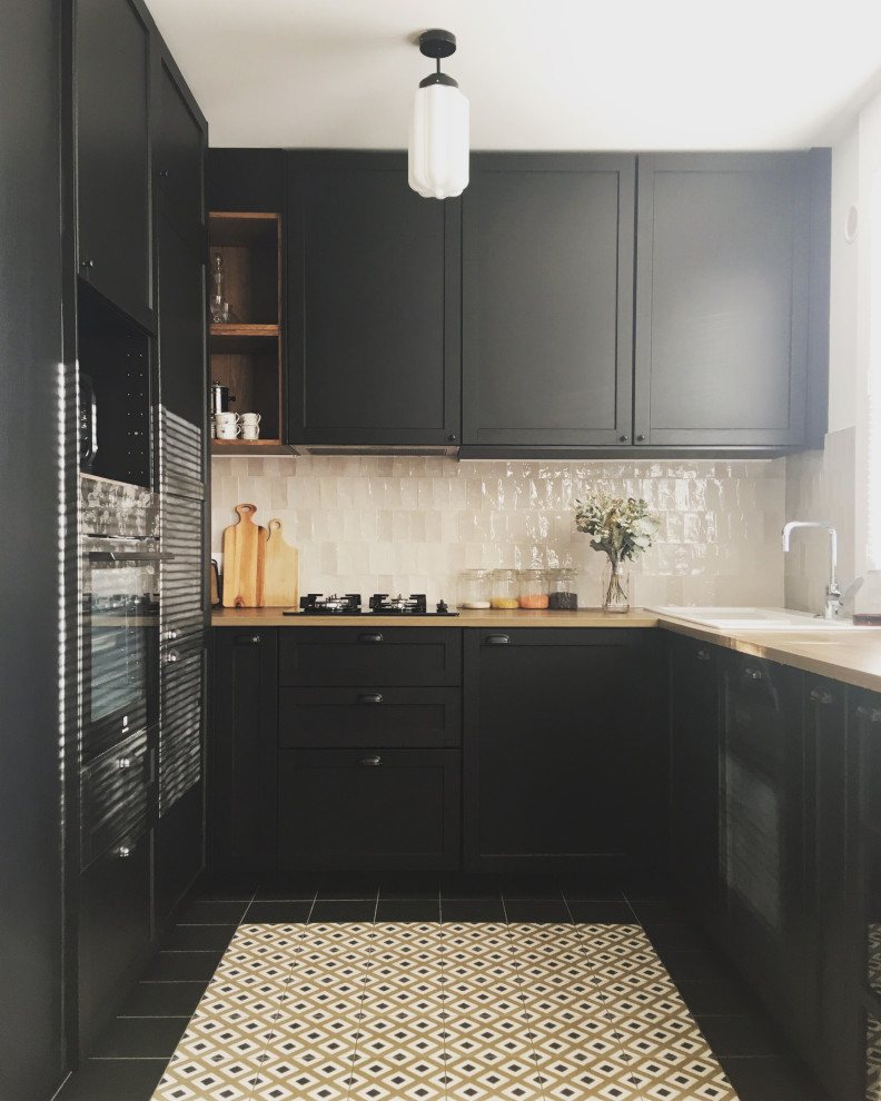 Inspiration för ett mellanstort 50 tals kök, med en enkel diskho, svarta skåp, laminatbänkskiva, beige stänkskydd, stänkskydd i keramik, integrerade vitvaror, klinkergolv i keramik och svart golv