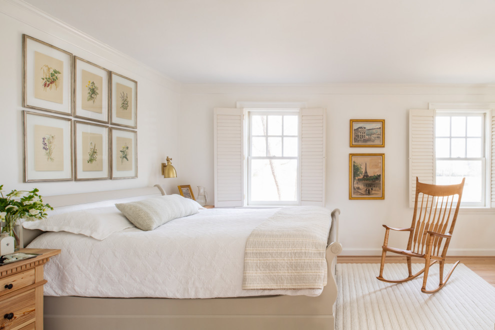 Photo of a mid-sized master bedroom in Austin with white walls, light hardwood floors and beige floor.