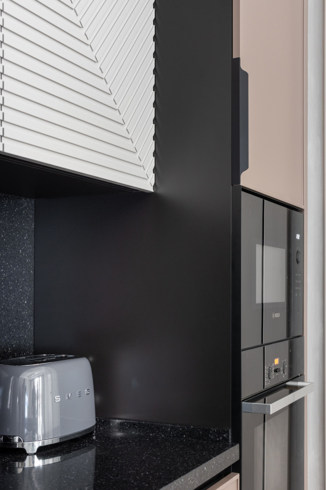 Modern inredning av ett stort svart linjärt svart kök med öppen planlösning, med luckor med profilerade fronter, bänkskiva i koppar, svart stänkskydd och en köksö