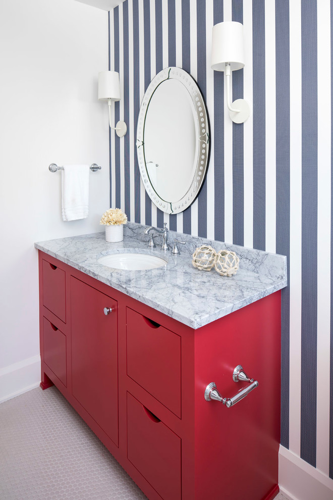 Photo of a mid-sized beach style 3/4 bathroom in Minneapolis with flat-panel cabinets, red cabinets, a curbless shower, a two-piece toilet, multi-coloured walls, ceramic floors, an undermount sink, marble benchtops, white floor and a hinged shower door.
