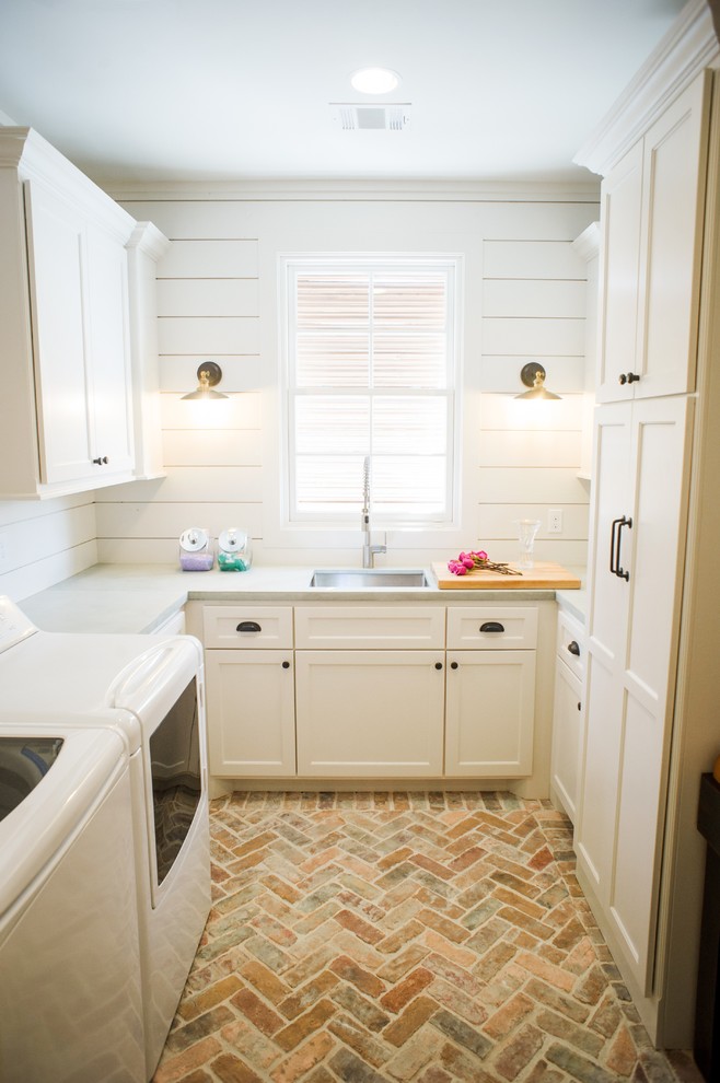 Mid-sized country u-shaped dedicated laundry room in Houston with an undermount sink, recessed-panel cabinets, white cabinets, white walls, brick floors, a side-by-side washer and dryer, beige floor, grey benchtop and concrete benchtops.