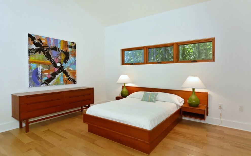 This is an example of a mid-sized midcentury master bedroom in Tampa with white walls, light hardwood floors and no fireplace.