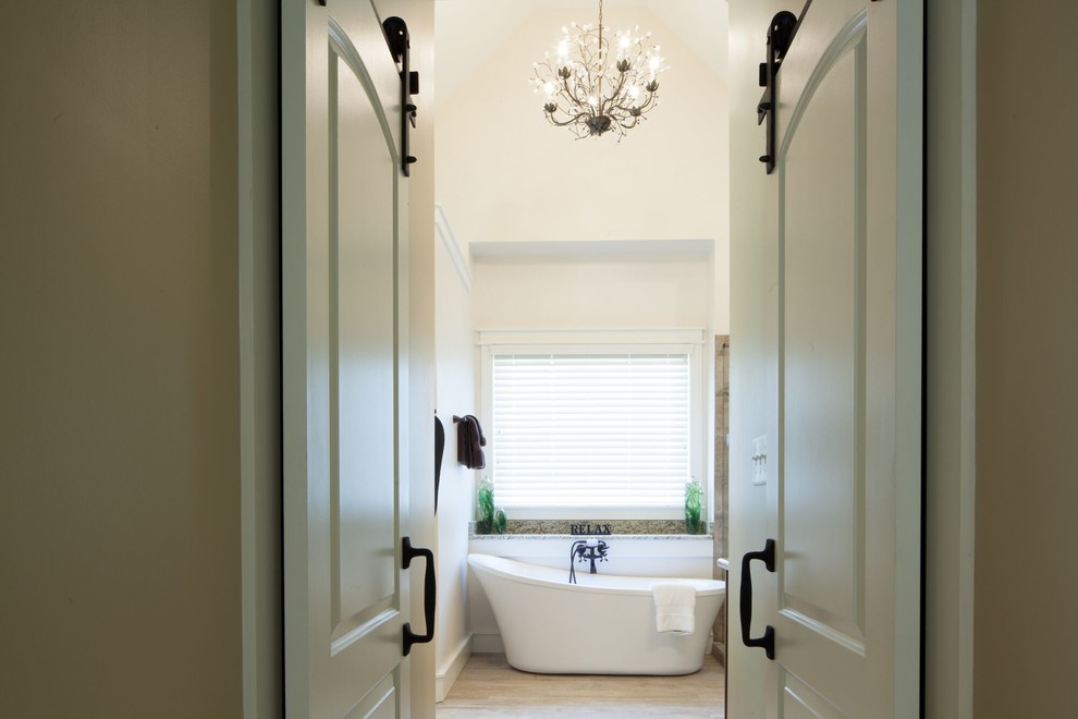 Inspiration for a mid-sized transitional master beige tile and stone tile ceramic tile and beige floor freestanding bathtub remodel with raised-panel cabinets, gray cabinets, beige walls, an undermount sink, granite countertops and a hinged shower door